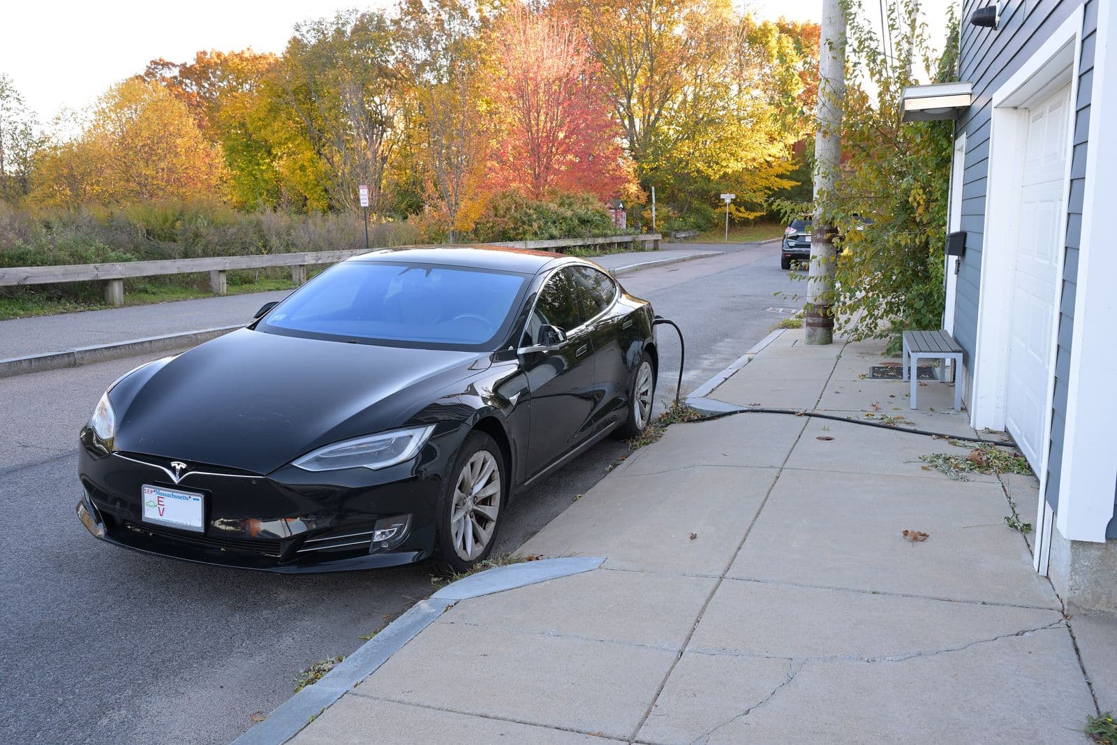 An electric vehicle charging at home in a residential driveway